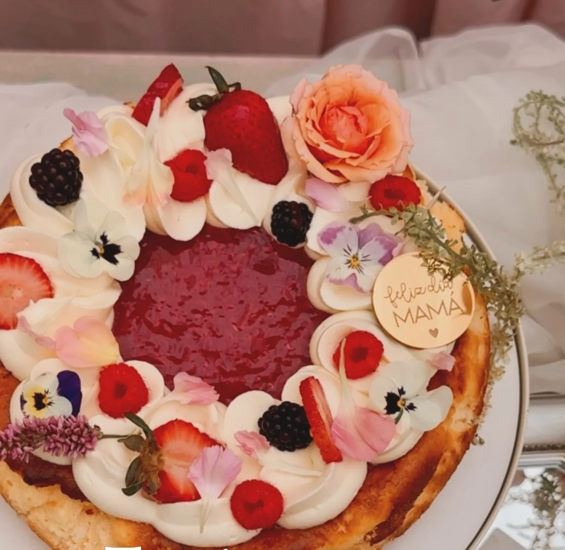 Tarta vasca con un borde de fresas, moras, frambuesas y pensamientos